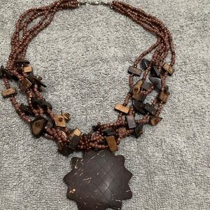 Multi-Strand Brown Beaded Necklace with Carved Pendant
